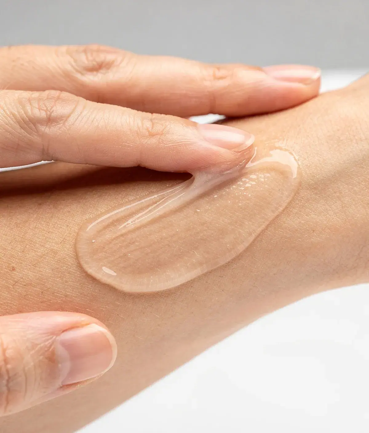 Gel corporal transparente extendido sobre el antebrazo con acabado seco y mate.