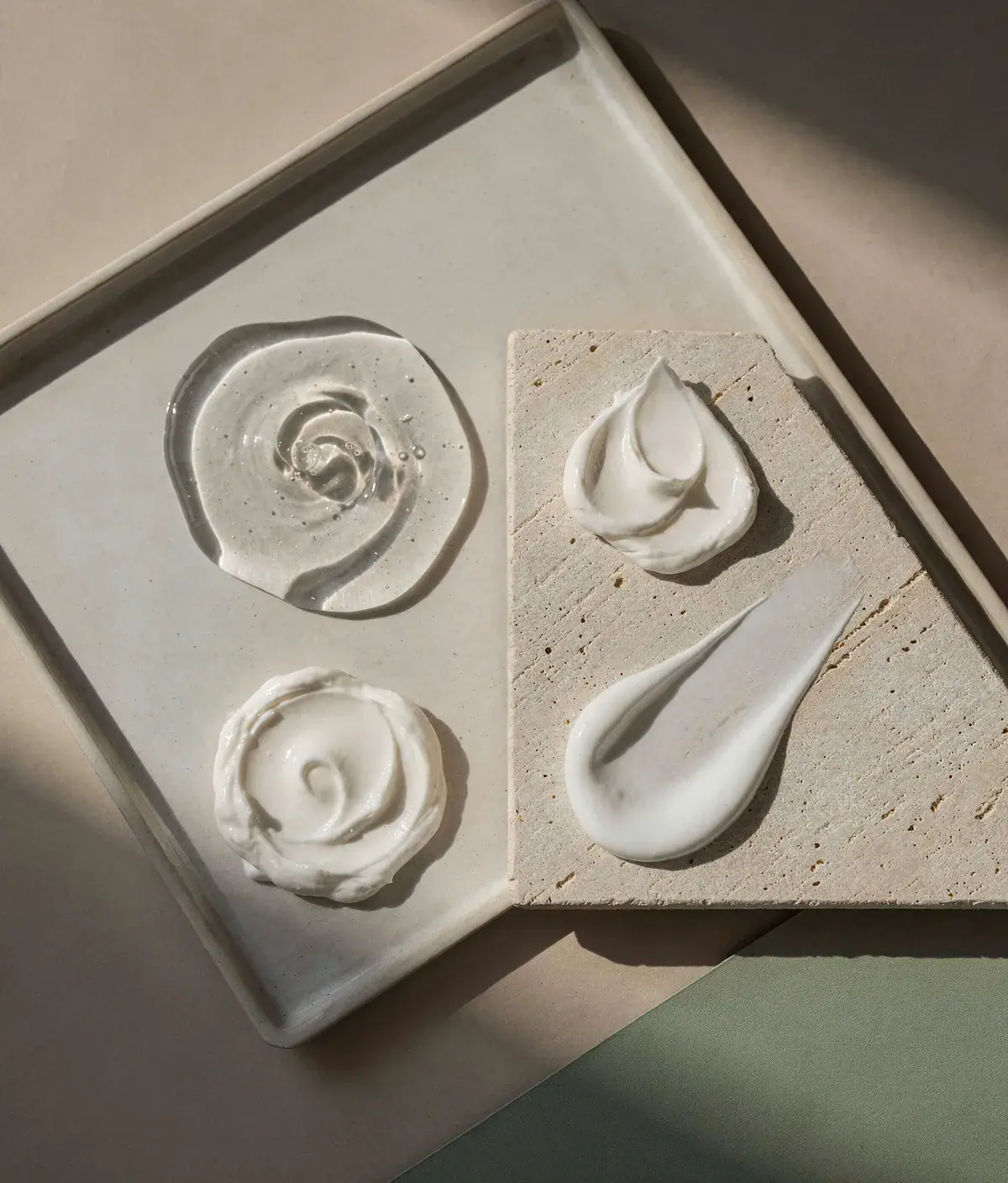Flat lay con gel, crema y emulsión anticelulítica sobre una bandeja minimalista en tonos crema y salvia.