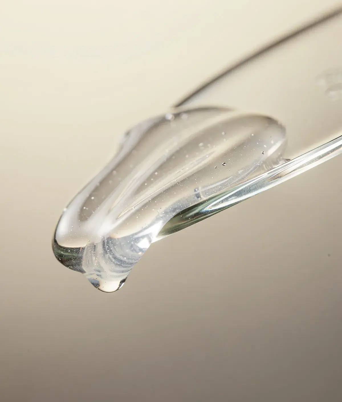 Textura de gel corporal transparente sobre una espátula de vidrio.