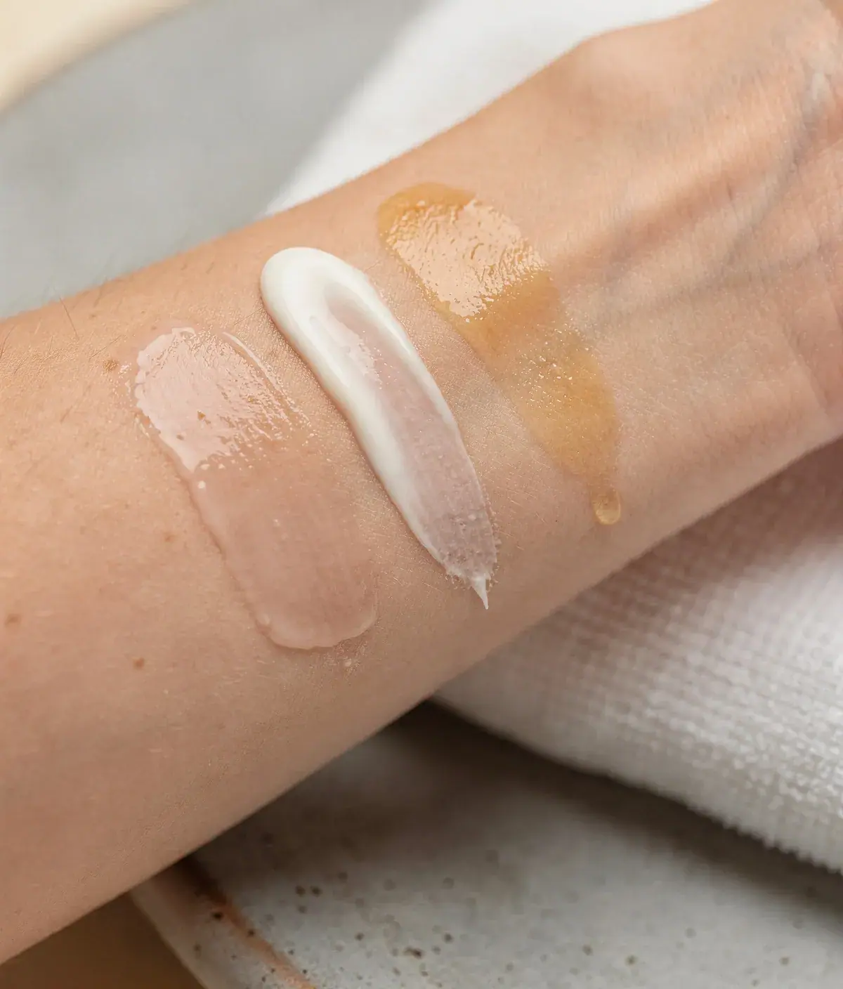 Mano aplicando leche corporal ligera sobre el antebrazo co